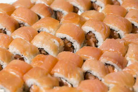 closeup of a tray of salmon uramaki filled with salmon and fresh cream cheeseの写真素材