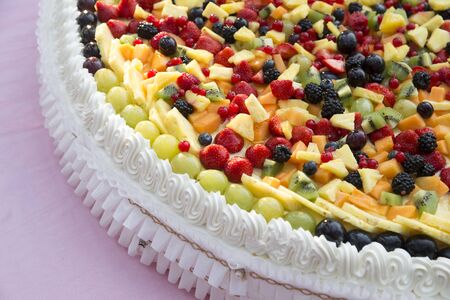 horizontal closeup of a wedding cake with whipped cream and fresh fruit on topの写真素材