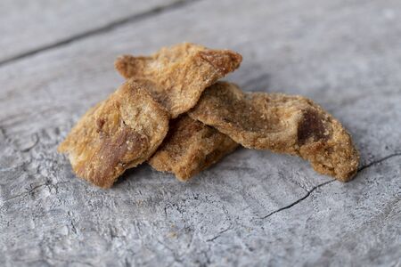 horizontal closeup of a typical italian appetizer: ciccioli. made from the fat of the pork on a gray wooden tableの写真素材