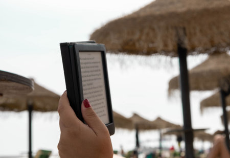 Reading from an E-Reader on the beach.