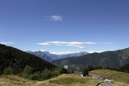 A landscape of green mountains, with pines and firs, rocks and glaciers, in the Vigezzo Valley, northern Italian Alpsの写真素材