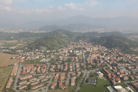 An areal landscape of the Po Valley (Pianura Padana) with forests, mountains, cultivated fields and cities, as seen from an airplaneの写真素材