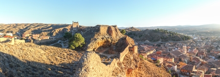 A landscape of the ancient Daroca fortifications and defensive walls on a hill, at the sunset, in Aragon, Spainのeditorial素材