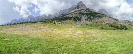 The mountains and the massif along the green path to the Piedrafita de Jaca lake in the aragonese Pyrenees mountainsの写真素材