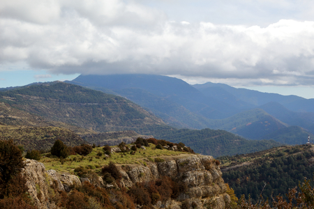 Blue cloudy sky and typical mountains and hills covered with forest met in autumn while hiking from the small Yebra de Basa town to Santa Orosia church on the Pyrenees mountains, Aragon, Spainの写真素材
