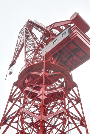 The restored red Carola crane (Grua Carola) in the Bilbao port, in the Basque Country, Spain, during a cloudy rainy day.の写真素材
