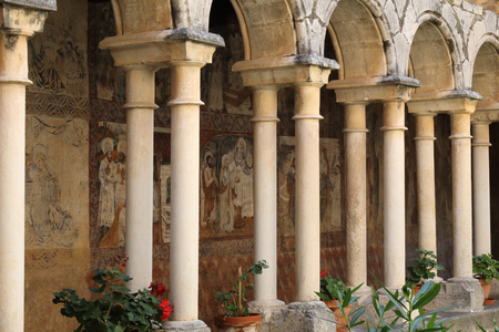 The inner cloister with romanesque arches and medieval frescos during a sunny day in the Colegiata de Santa Maria la Mayor of Alquezar, Spainのeditorial素材