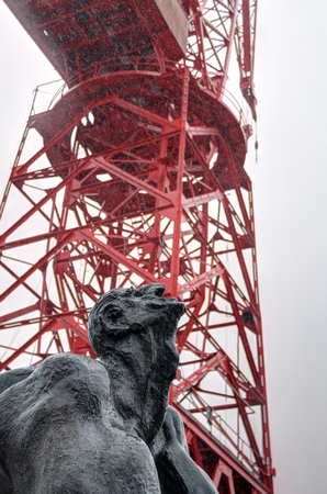 Hombre Tuercebarras (bar bending man) sculpture in front of the red Grua Carola (Carola crane) in Bilbao, Basque Country, Spain, during a rainy dayのeditorial素材