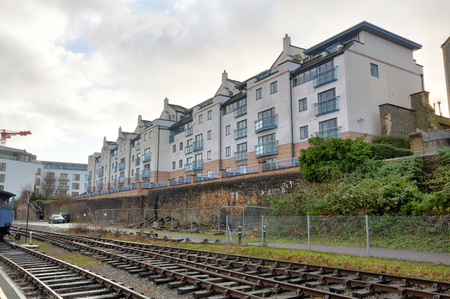 Rails next to a street in front of terrace houses during a cloudy and rainy winter day in Spike Island, Bristol, United Kingdomの写真素材