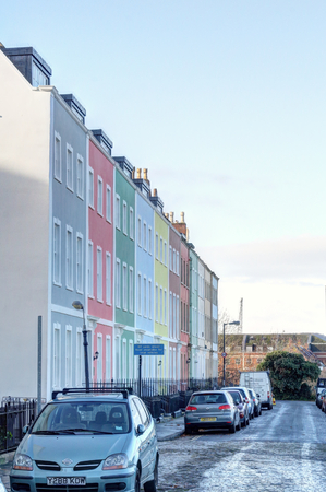 Bristol, United Kingdom - November 30, 2018: Blue, grey, green, yellow and colored terrace houses next to a street with parked cars during a sunny day in Bristol, United Kingdomのeditorial素材