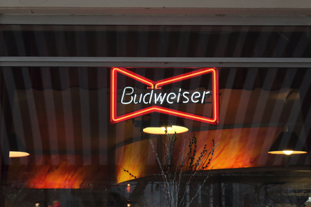 Bristol, United Kingdom - November 30, 2018: A red Budweiser beer neon sign on a pub window, with a dark backgroundのeditorial素材