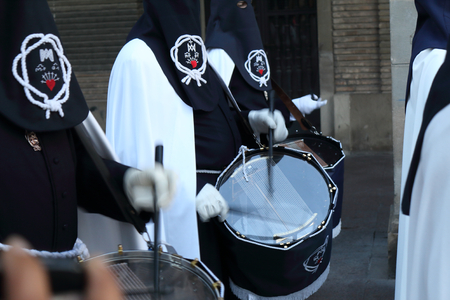 Zaragoza, Spain - April 13, 2017: A marching band playing drums in a catholic brotherhood with the capirote pointed hat during the Holy Week procession in Zaragoza, Aragon, Spainのeditorial素材