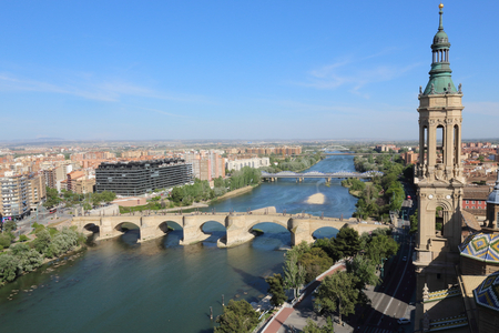 A landscape of Zaragoza with the Puente de Piedra and Puente de Hierro bridges, the Ebro river and a Pilar Cathedral bell tower, in Aragon, Spainの写真素材