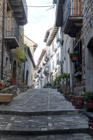 A rural street of a Pyrenees mountain hamlet with stone houses with wooden balconies and dark roofs during winter in Ansó, Aragon region, Spainのeditorial素材
