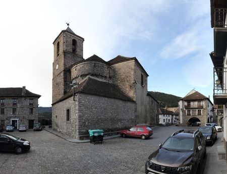 The stone made, modern Saint Martin's church (Iglesia de San Martin) and its square with parked cars...