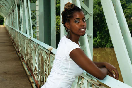 african american stands on bridgeの写真素材