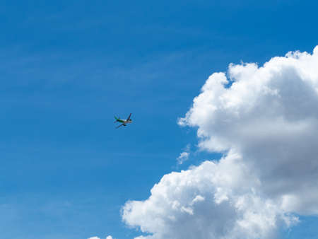 Landscape view clear blue sky with bright white clouds and the airplane flyingの写真素材