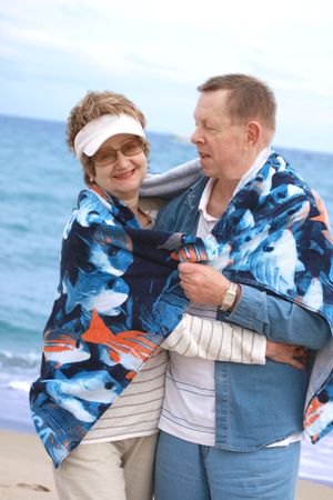 Couple at the beach hugging and smiling