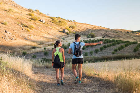couple doing trekking through the fieldの写真素材