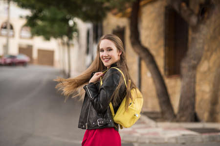 Happy young man with hair moving in urban background.
