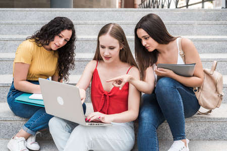 Student girls on the stairs studying with laptopの写真素材