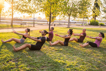 Group of people practicing yoga outdoorsの写真素材