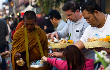 CHIANG KHAN, THAILAND - Jan 1, 2015 : Tourists offerings food to monksのeditorial素材