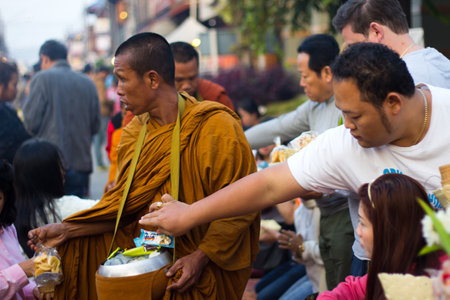 CHIANG KHAN, THAILAND - Jan 1, 2015 : Tourists offerings food to monksのeditorial素材