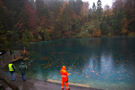 Tourists fishing for trout at Blausee lake, Switzerland
