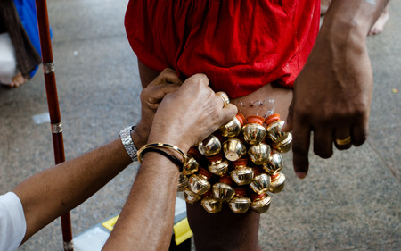 A devotee hook with bells pierced into legs in Thaipusamの写真素材