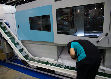 Worker operating bottle cap making machine