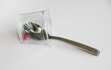 Empty a cup of strawberry jelly with spoon insideの写真素材