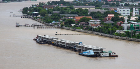 Bangkok, Thailand - July 29, 2017: Barge loading bridge components on Chaopraya river