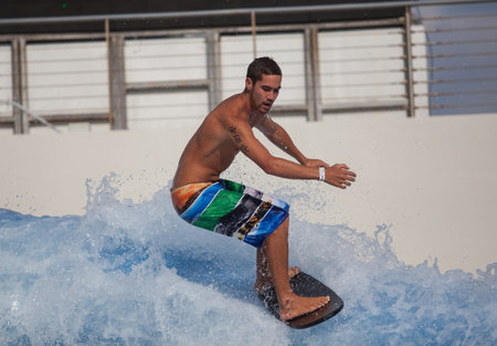 Sentosa, Singapore - June 19, 2010: A man surf flowboarding at Wave House Sentosaのeditorial素材