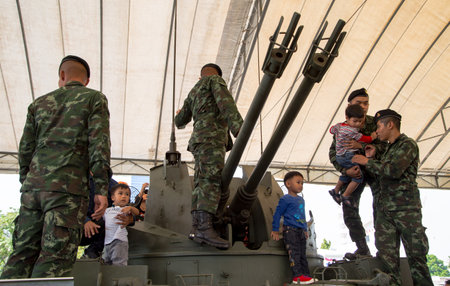 Bangkok, Thailand - January 13, 2018: Asian boys play on tank in Thai Army base open to public in...