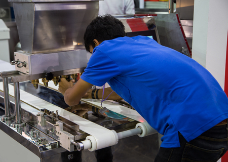 Food worker operate bakery making machine