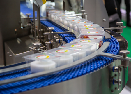 Packing food in plastic box in production line