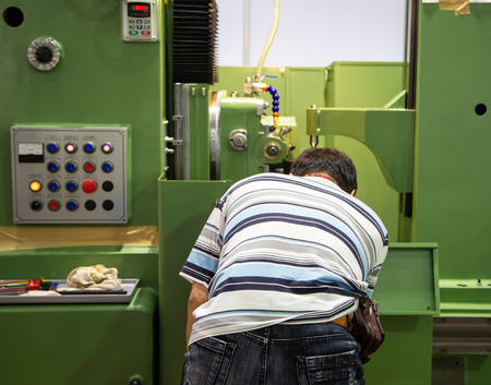 Worker operate CNC machine in factory, industrial machining