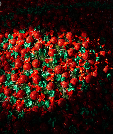 Sunshine on decorated Chirstmas tree with red ball and green ribbonの写真素材