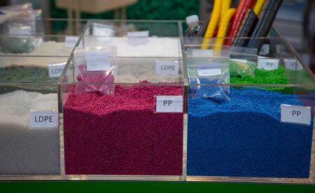 Colorful of dyed plastic polymer granules in containers
