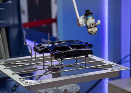 Robotic arm painting car part in automotive industry