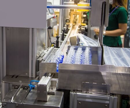 Production line collecting empty plastic bottle from blowing machine before packing in plastic bag