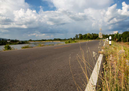 Empty asphalt road. View of country road. Street view along a river.