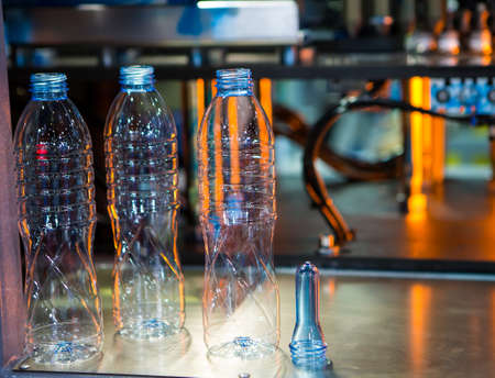 Plastic bottles and raw material for plastic bottle manufacturing process on plastic bottle blowing machine.の写真素材