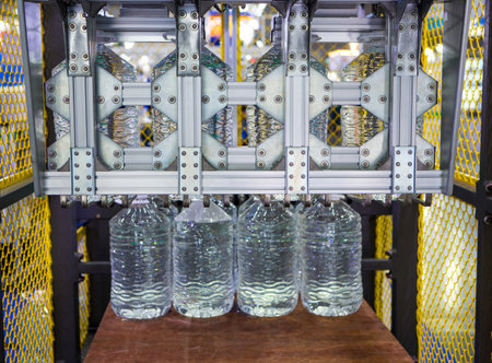Machine moving 5 litre water bottles in warehouse.
