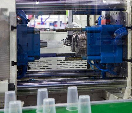 Plastic cups from plastic injection molding press machine. Industrial manufacturingの写真素材