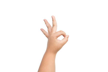 Children hand is making OK gesture meaning success or everything is all right isolated on white backgroundの写真素材