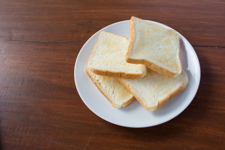 Toast on a white plate on a wooden