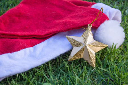 christmas star and christmas red hat on beautiful grassの写真素材