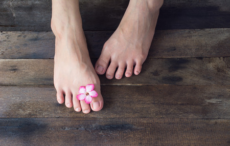Beautiful female feet on wood backgroundの写真素材